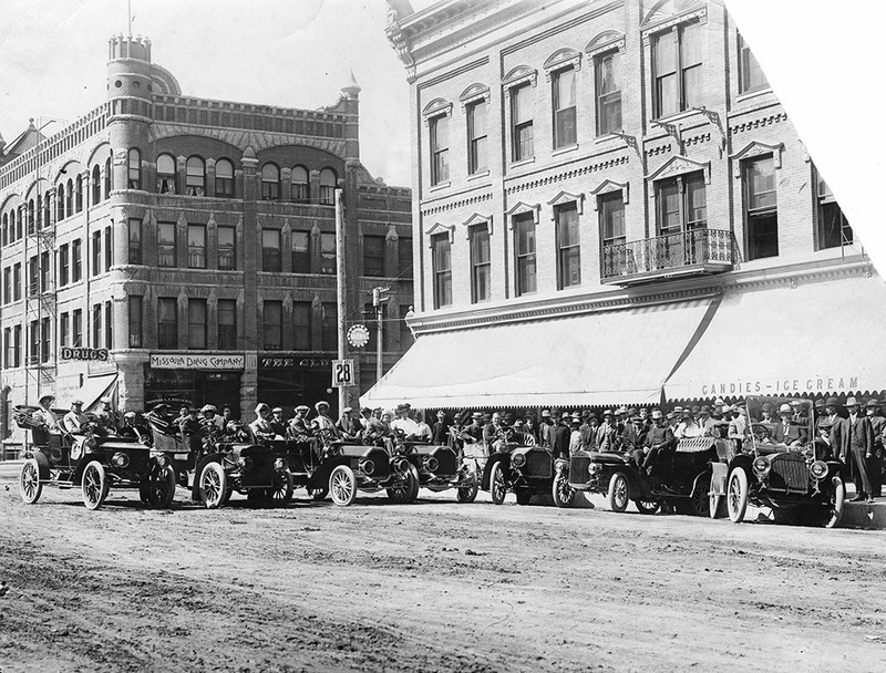 Early automobile touring group posed on Higgins Avenue in front of the Florence Hotel, Missoula, Montana.